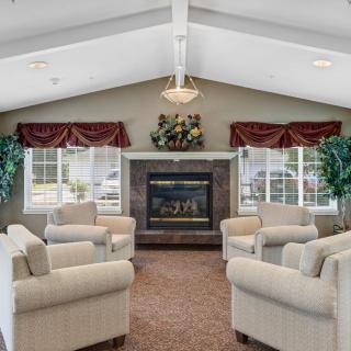 A cozy living room with a central fireplace surrounded by sofas.
