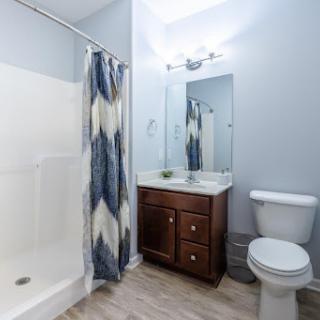 A modern bathroom featuring a shower, toilet, and stylish vanity.