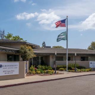 A well-maintained building displaying the American flag and surrounded by lush landscaping.