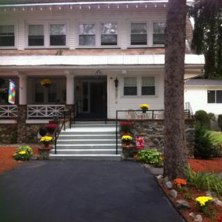 A charming two-story house with a beautifully landscaped front yard.