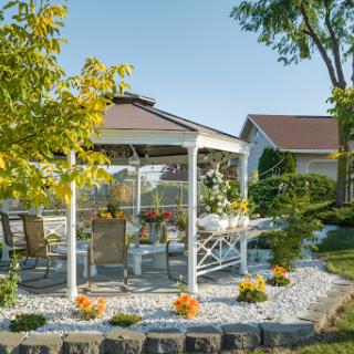 A serene garden gazebo surrounded by lush greenery and beautiful flowers, perfect for outdoor relaxation.