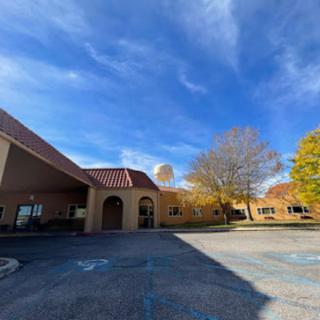 A picturesque view of a building surrounded by autumn foliage under a clear blue sky.