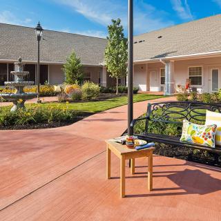 A serene courtyard with a fountain, surrounded by landscaped gardens and outdoor seating.