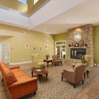 A cozy living room with a stone fireplace, comfortable seating, and warm lighting.