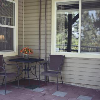 A cozy patio area with a table, two chairs, and a window view.