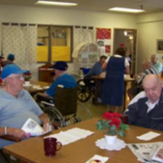 Elderly residents in a nursing home setting, sitting and socializing.