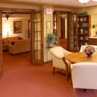 A cozy and well-furnished interior space featuring comfortable seating, a table, and a bookshelf.