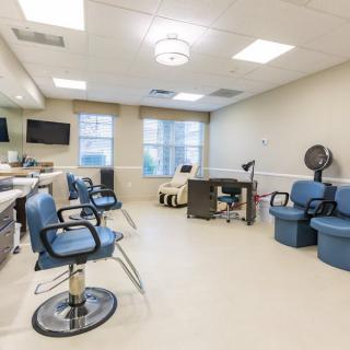 A modern and clean hair salon interior with barber chairs and a waiting area.