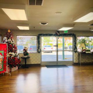 A festive lobby decorated for the Christmas season, featuring a colorful tree and holiday decorations.