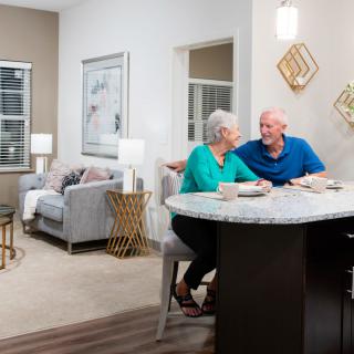 Elderly couple enjoying a meal in a cozy home setting.
