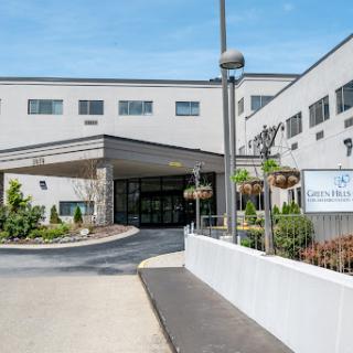 The entrance of a modern building with landscaped surroundings.
