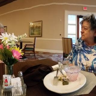 A warm gathering over a meal, featuring engaging conversation and floral decor.