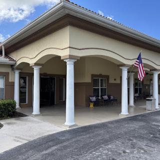 A well-designed entrance showcasing columns and a flag, typical of warm climate architecture.