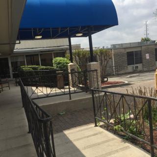 A walkway with a blue awning leading to a building entrance.