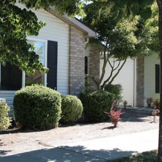 A charming residential house with well-maintained landscaping and greenery.