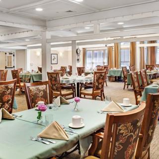 An elegantly set dining room with neatly arranged tables and chairs.