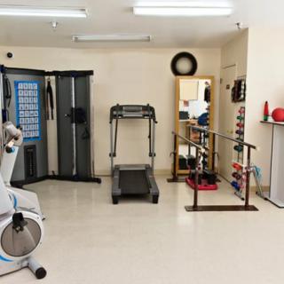 A well-equipped gym room with various fitness machines and weights.
