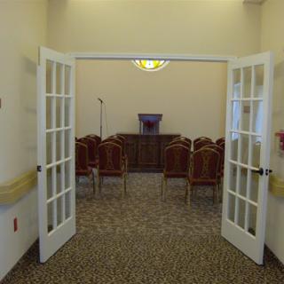 A view of a formal meeting space with chairs arranged neatly and a podium at the front.