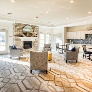 A spacious and elegantly designed living room featuring a fireplace, comfortable seating, and modern decor.
