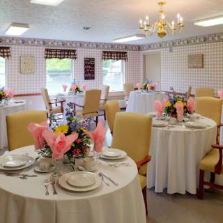 An elegantly set dining area featuring beautifully arranged tables with floral centerpieces.