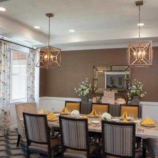 An elegant dining room with stylish chandeliers and a beautifully set table.