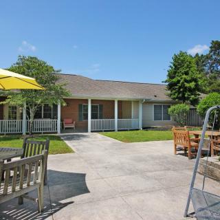 A sunny backyard with patio furniture and a view of the house.