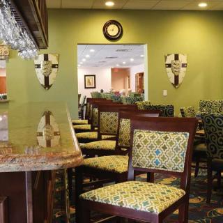 A cozy restaurant interior with patterned chairs and a bar area.