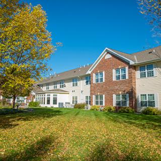 A sunny autumn day showcasing a charming residential building with a lush green lawn.