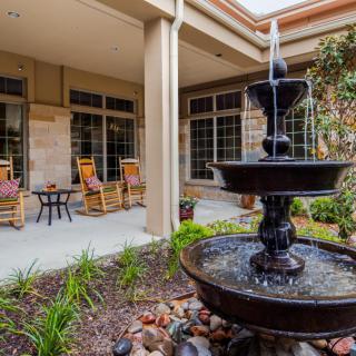 A serene courtyard featuring a multi-tiered fountain and comfortable outdoor seating.