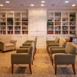 A cozy lounge area with comfortable seating and bookshelves.
