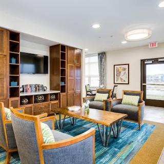A modern lounge area featuring comfortable seating, bookshelves, and a television, designed for relaxation and social interaction.