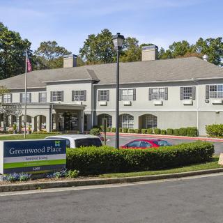 A hospital building with a parking area and surrounding greenery.