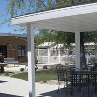 An outdoor patio area with a pergola and garden furniture.