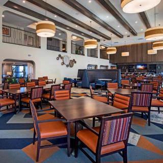 A modern and spacious restaurant interior with arranged seating and stylish lighting.