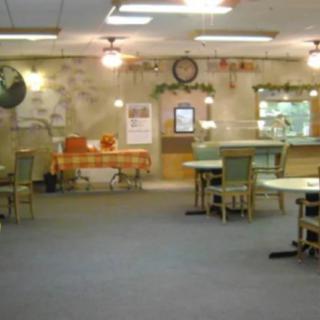 An empty restaurant interior with tables and chairs arranged across the floor.