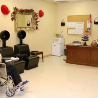 A waiting area with a person in a wheelchair, salon chairs, and decorative elements.