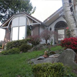 A charming house with a well-maintained garden, featuring unique architectural details.