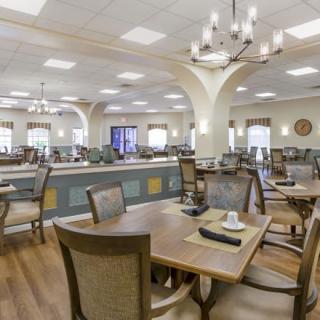 A spacious dining room with elegant furniture and chandeliers.