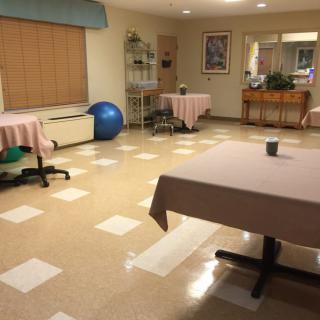 A rehabilitation room with exercise equipment and tables for therapy.