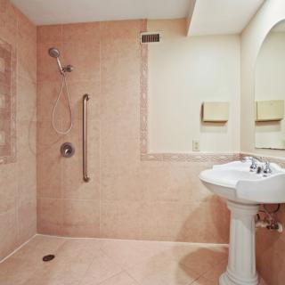 A spacious bathroom with a walk-in shower and pedestal sink.