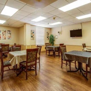 A cozy dining area featuring tables and chairs, complemented by wooden flooring and decorative wall art.