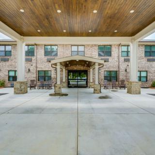 Front entrance of a brick building with a covered walkway and columns.