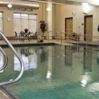 An inviting indoor swimming pool area with seating and warm lighting.