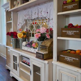 A beautifully arranged shelf showcasing vibrant flowers and decorative storage boxes, enhancing the cozy atmosphere of a home.