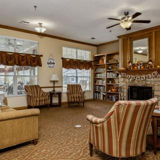 Cozy living room with a fireplace, bookshelves, and comfortable seating.