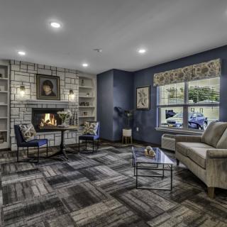 A cozy living room with a fireplace, bookshelves, and comfortable seating.
