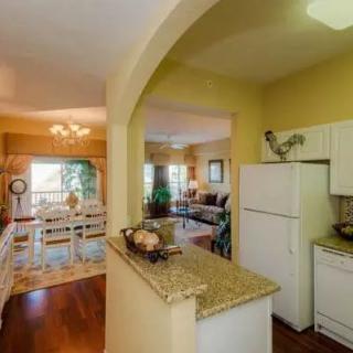 A cozy home interior featuring an open floor plan with a kitchen and dining area separated by an archway.