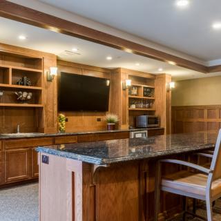 A modern kitchen interior featuring wooden cabinets and an island counter with bar stools.