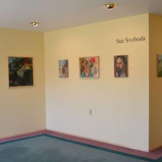 An art gallery wall displaying a collection of paintings.