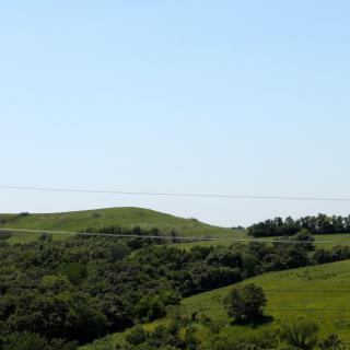 A scenic view of lush green hills under a clear blue sky.